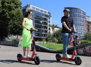 a woman and a man are on electric scooters for adults